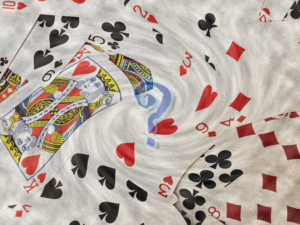 An image of playing cards swirling around a question mark.